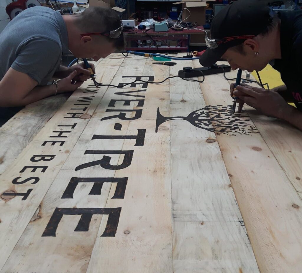 On Event Production Company | Live, Hybrid and Virtual Event Production | Fever Tree logo painting on planks